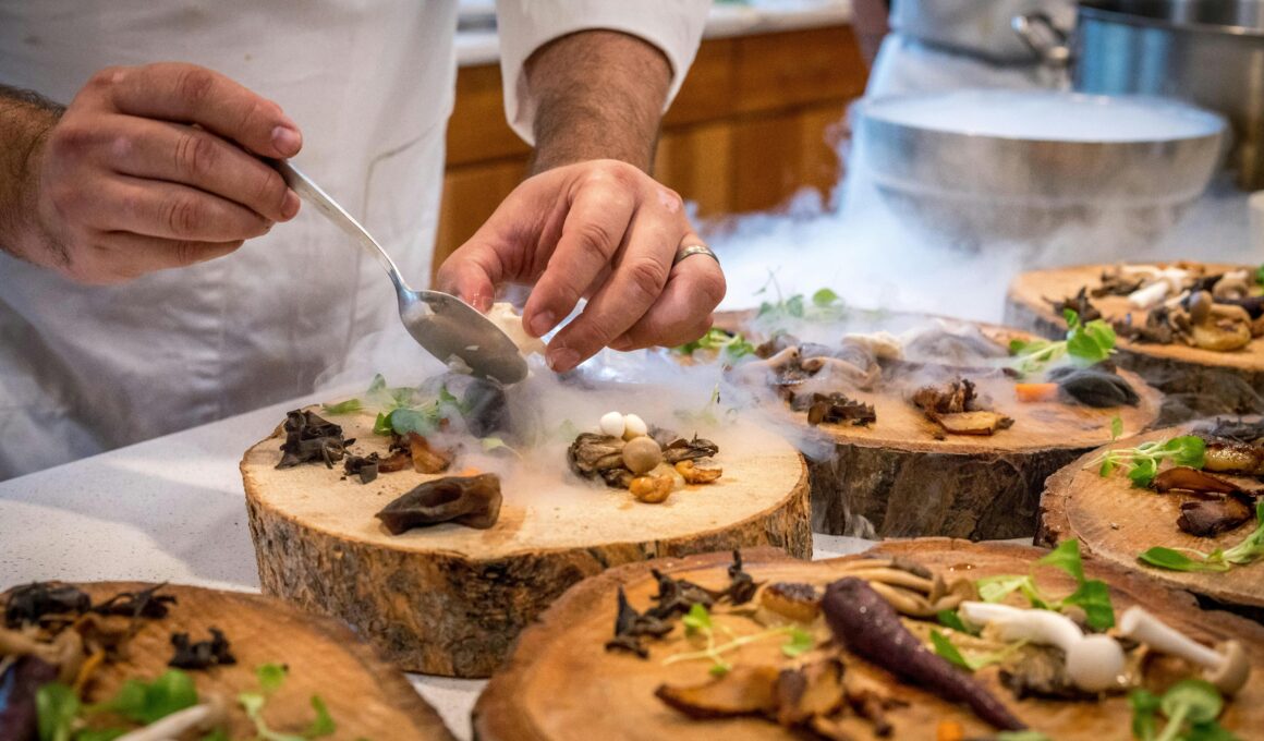 A chef artfully plating a gourmet dish with mushrooms and greens on wood slices.