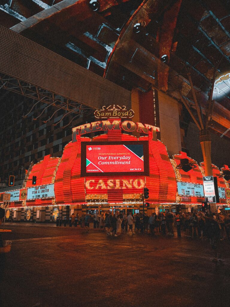 Night view of the iconic Sam Boyd's Fremont Casino in Las Vegas, bustling with activity and neon lights.